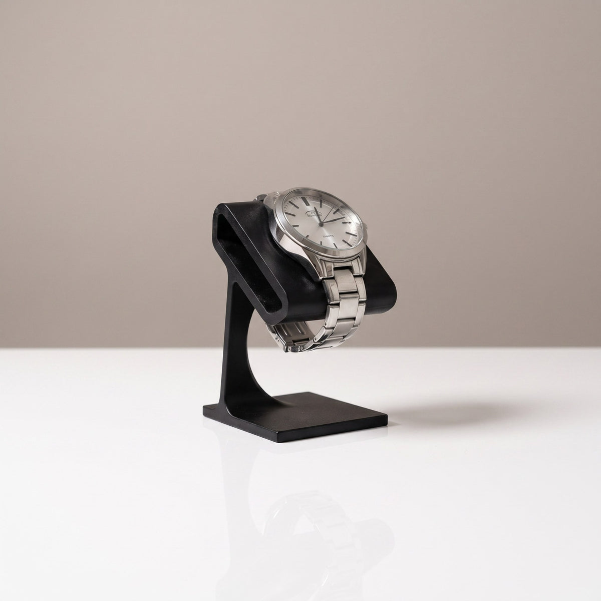 Solitaire watch stand in Graphite holding a steel watch