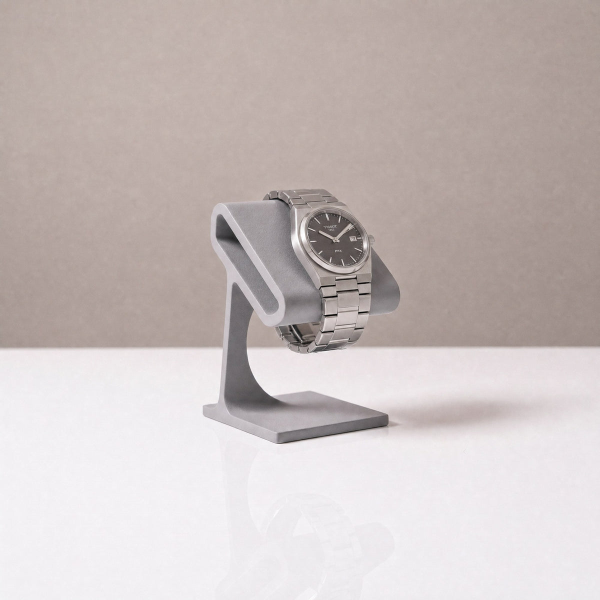 Solitaire watch stand in Stone grey holding a steel watch