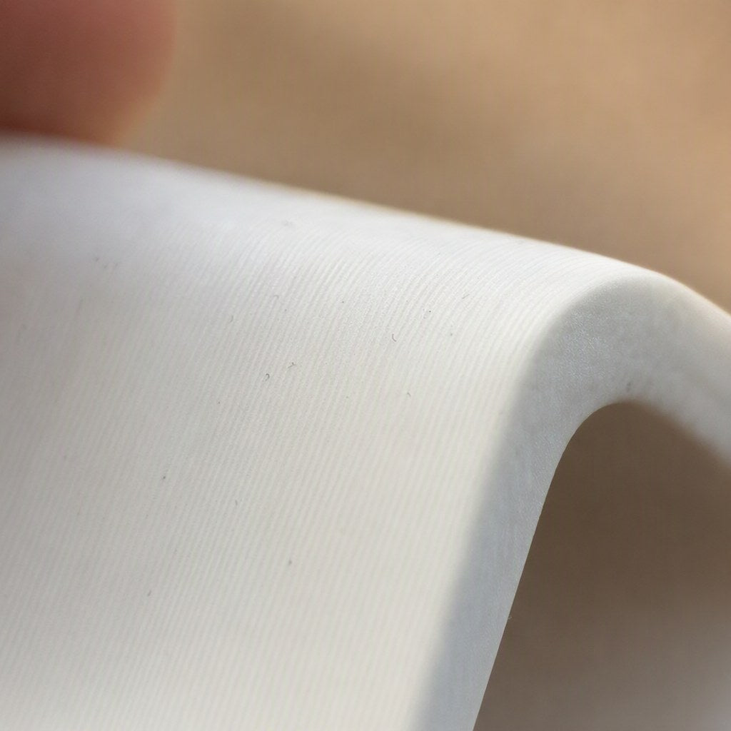 Detail of material surface showing fiber grain and hand-finished matte polish