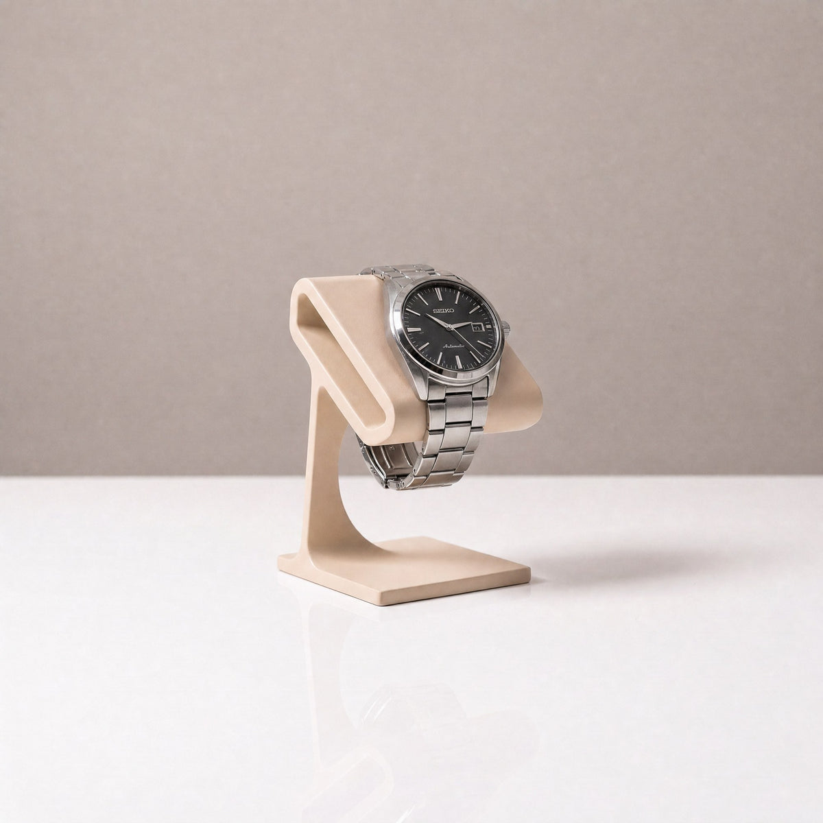 Solitaire watch stand in Sand beige holding a steel watch